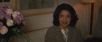 Movie still from “Creed II” (2018), directed by Steven Caple Jr. – A woman sitting on a couch in front of a painting; Close Up shot, Over the shoulder angle