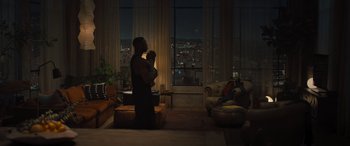 Movie still from “Creed II” (2018), directed by Steven Caple Jr. – A man holding a baby in his arms in front of a window; Wide shot, High angle