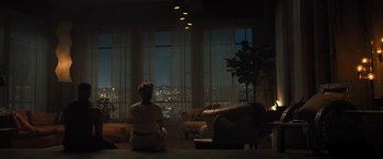 Movie still from “Creed II” (2018), directed by Steven Caple Jr. – A woman sitting on the floor in front of a large window; Wide shot, High angle