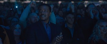 Movie still from “Creed II” (2018), directed by Steven Caple Jr. – A group of people in a dark room; Medium shot, Low angle