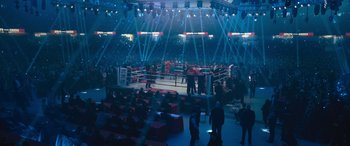 Movie still from “Creed II” (2018), directed by Steven Caple Jr. – A boxing ring is lit up at night time; Extreme Wide shot, High angle