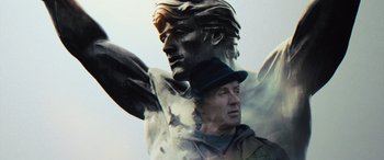 Movie still from “Creed II” (2018), directed by Steven Caple Jr. – A statue of a man with a hat on; Close Up shot, Low angle