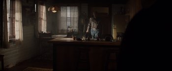 Movie still from “Cry Macho” (2021), directed by Clint Eastwood – A man standing in the middle of a kitchen; Wide shot, Over the shoulder angle