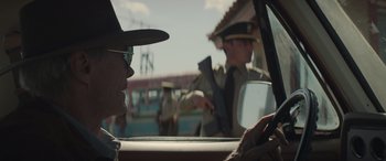 Movie still from “Cry Macho” (2021), directed by Clint Eastwood – A man in a hat sitting in the drivers seat of a car; Close Up shot, Over the shoulder angle
