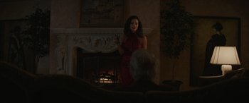 Movie still from “Cry Macho” (2021), directed by Clint Eastwood – A woman standing in front of a man in front of a fireplace; Medium shot, Over the shoulder angle