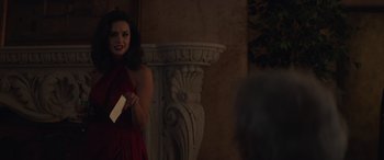 Movie still from “Cry Macho” (2021), directed by Clint Eastwood – A woman in a red dress holding a piece of paper; Medium shot, Over the shoulder angle