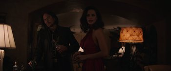 Movie still from “Cry Macho” (2021), directed by Clint Eastwood – A woman standing next to a man holding a wine glass; Medium shot, Low angle