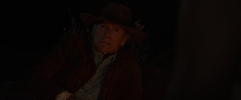 Movie still from “Cry Macho” (2021), directed by Clint Eastwood – An older man wearing a hat and a brown jacket; Close Up shot, Low angle
