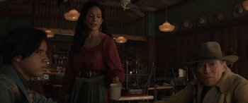 Movie still from “Cry Macho” (2021), directed by Clint Eastwood – A woman holding a coffee cup in a room; Medium shot, Over the shoulder angle