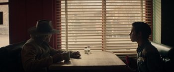 Movie still from “Cry Macho” (2021), directed by Clint Eastwood – A table that has some cups on it; Medium shot, Over the shoulder angle