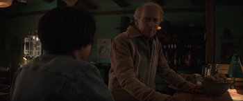 Movie still from “Cry Macho” (2021), directed by Clint Eastwood – An older man and a young boy in a room; Medium shot, Over the shoulder angle