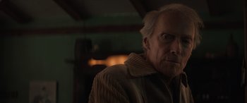 Movie still from “Cry Macho” (2021), directed by Clint Eastwood – An old man with a gray beard is looking at the camera; Close Up shot, Over the shoulder angle