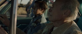 Movie still from “Cry Macho” (2021), directed by Clint Eastwood – A man and a woman sitting in a car; Medium shot, Over the shoulder angle