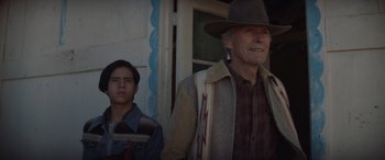 Movie still from “Cry Macho” (2021), directed by Clint Eastwood – A man and a young boy standing next to each other; Medium shot, Over the shoulder angle