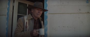 Movie still from “Cry Macho” (2021), directed by Clint Eastwood – An old man holding a cup in his hand; Close Up shot, Over the shoulder angle