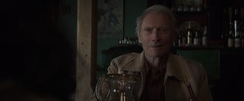Movie still from “Cry Macho” (2021), directed by Clint Eastwood – An older man sitting in front of a coffee pot; Close Up shot, Over the shoulder angle