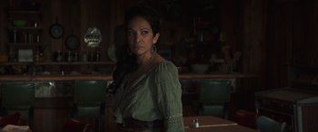 Movie still from “Cry Macho” (2021), directed by Clint Eastwood – A woman in a green shirt is posing for a picture; Medium shot, Low angle