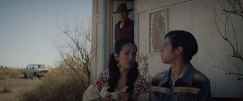 Movie still from “Cry Macho” (2021), directed by Clint Eastwood – A woman and a man standing in front of a house; Medium shot, Over the shoulder angle