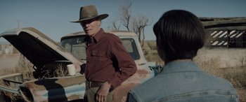 Movie still from “Cry Macho” (2021), directed by Clint Eastwood – A man and a woman standing in front of an old truck; Medium shot, Over the shoulder angle