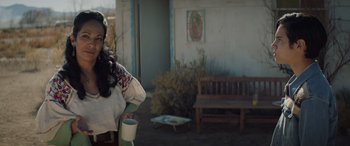 Movie still from “Cry Macho” (2021), directed by Clint Eastwood – A woman holding a coffee cup in her hand; Medium shot, Over the shoulder angle