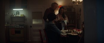 Movie still from “Cry Macho” (2021), directed by Clint Eastwood – A man and a woman standing at a dinner table; Medium shot, Over the shoulder angle