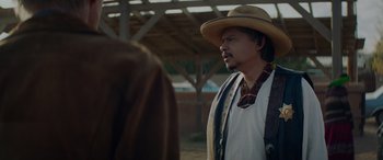 Movie still from “Cry Macho” (2021), directed by Clint Eastwood – A man wearing a cowboy hat standing next to another man; Medium shot, Over the shoulder angle