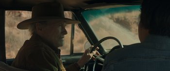 Movie still from “Cry Macho” (2021), directed by Clint Eastwood – An older man driving a car in the desert; Close Up shot, Over the shoulder angle