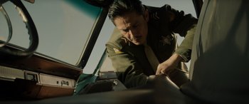 Movie still from “Cry Macho” (2021), directed by Clint Eastwood – A man in a uniform working on something in a vehicle; Medium shot, Low angle