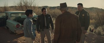 Movie still from “Cry Macho” (2021), directed by Clint Eastwood – Two men and a woman talking to an officer; Medium shot, Over the shoulder angle