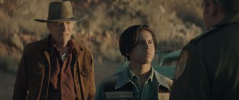 Movie still from “Cry Macho” (2021), directed by Clint Eastwood – A young man standing next to another young man; Medium shot, Over the shoulder angle