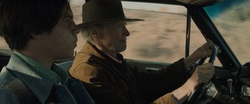 Movie still from “Cry Macho” (2021), directed by Clint Eastwood – An older man in a hat driving a car; Close Up shot, Over the shoulder angle