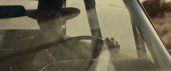 Movie still from “Cry Macho” (2021), directed by Clint Eastwood – A man in a hat driving in a car; Close Up shot, Low angle
