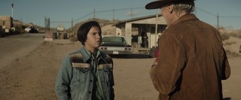 Movie still from “Cry Macho” (2021), directed by Clint Eastwood – Two people standing on a dirt road talking to each other; Medium shot, Over the shoulder angle