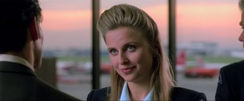 Movie still from “Crying Freeman” (1995), directed by Christophe Gans – A woman in a business suit smiling for the camera; Close Up shot, Low angle