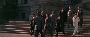 Movie still from “Crying Freeman” (1995), directed by Christophe Gans – A group of men in suits walking down a set of stairs; Wide shot, Low angle