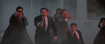 Movie still from “Crying Freeman” (1995), directed by Christophe Gans – A group of men in suits and ties standing next to each other; Medium shot, Low angle