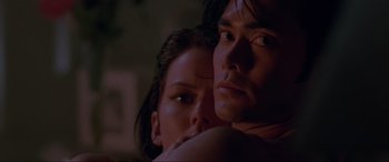 Movie still from “Crying Freeman” (1995), directed by Christophe Gans – A man and a woman embracing each other in a dark room; Close Up shot, Low angle