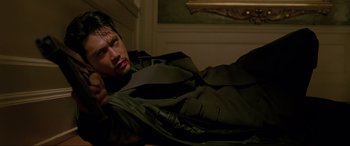 Movie still from “Crying Freeman” (1995), directed by Christophe Gans – A man laying on the ground wearing a jacket; Medium shot, Low angle