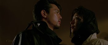 Movie still from “Crying Freeman” (1995), directed by Christophe Gans – A man and a woman looking at one another; Close Up shot, Low angle