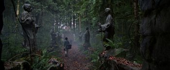 Movie still from “Crying Freeman” (1995), directed by Christophe Gans – A group of statues in the middle of a forest; Extreme Wide shot, Low angle