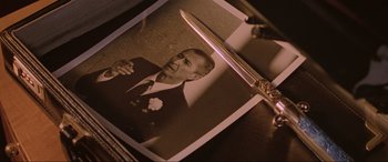 Movie still from “Crying Freeman” (1995), directed by Christophe Gans – An old photo of a man holding a knife; Extreme Close Up shot, High angle
