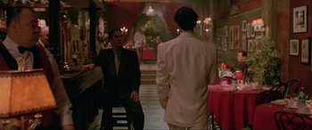 Movie still from “Crying Freeman” (1995), directed by Christophe Gans – A man in a suit and tie standing next to another man in a suit and tie; Medium shot, Over the shoulder angle
