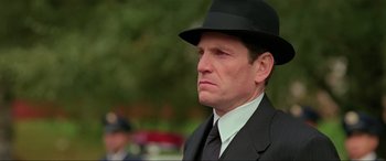 Movie still from “Crying Freeman” (1995), directed by Christophe Gans – A man in a suit and a black hat; Close Up shot, Low angle