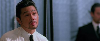 Movie still from “Crying Freeman” (1995), directed by Christophe Gans – A person wearing a shirt and a tie; Close Up shot, Low angle