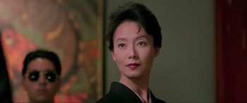 Movie still from “Crying Freeman” (1995), directed by Christophe Gans – A person with short black hair; Close Up shot, Low angle