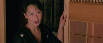 Movie still from “Crying Freeman” (1995), directed by Christophe Gans – A woman leaning against a wall in a room; Close Up shot, High angle