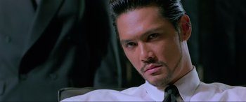 Movie still from “Crying Freeman” (1995), directed by Christophe Gans – A person wearing a suit and tie; Close Up shot, Low angle