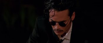 Movie still from “Crying Freeman” (1995), directed by Christophe Gans – A person wearing a suit and sunglasses; Close Up shot, Low angle