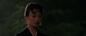 Movie still from “Crying Freeman” (1995), directed by Christophe Gans – A woman in a black kimono is standing in the dark; Close Up shot, Low angle