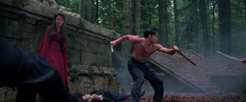 Movie still from “Crying Freeman” (1995), directed by Christophe Gans – A man with a gun in his hand and another man laying on the ground; Wide shot, Low angle